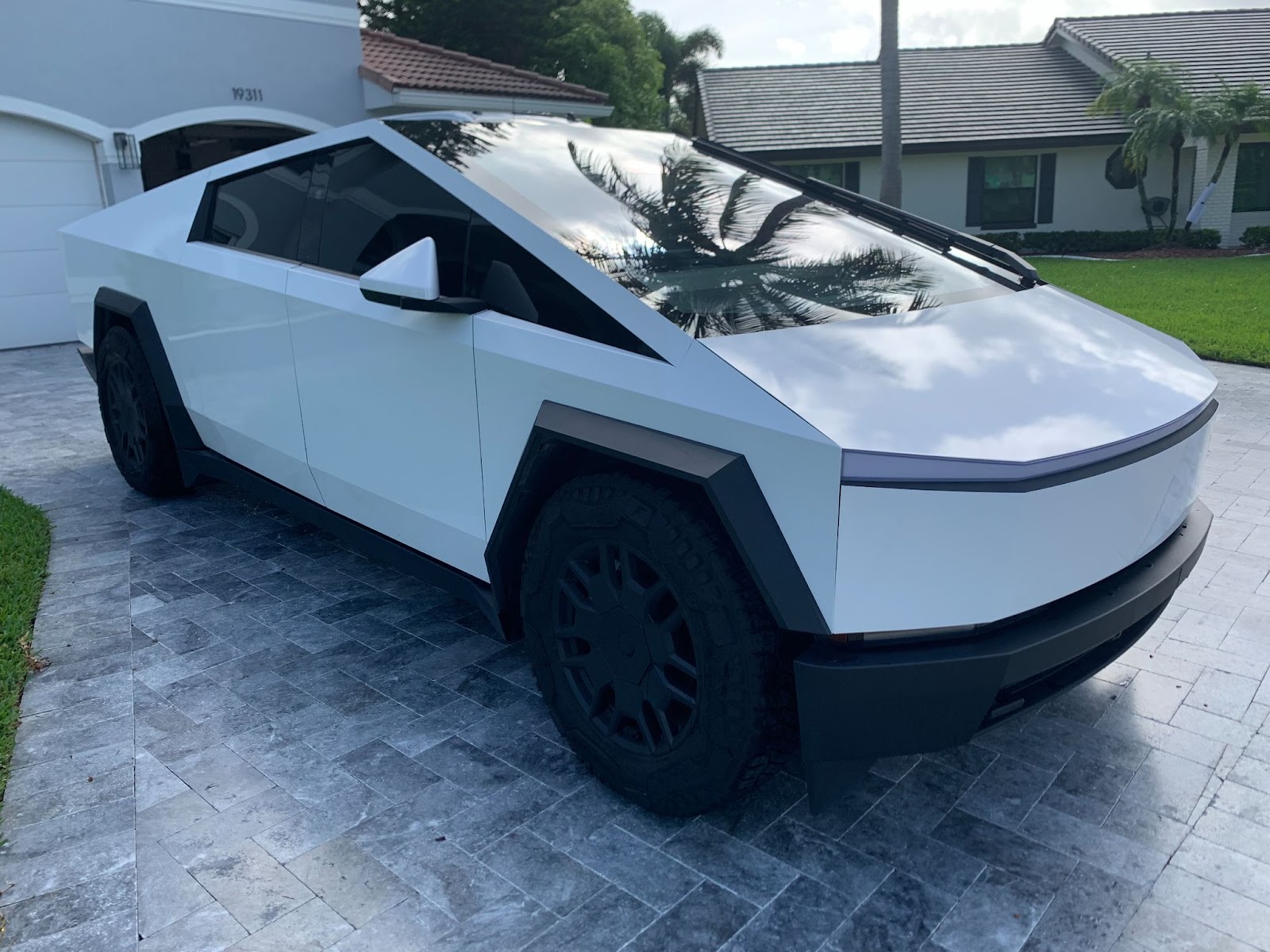 White Custom Cybertruck parked in a South Florida driveway, ideal for brand personalization and high-end event rentals